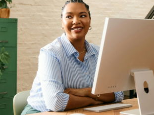 A woman smiling while working at a computer